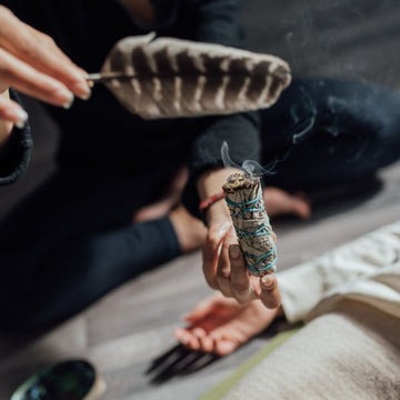 Woman smudging with Certified organic white sage stick